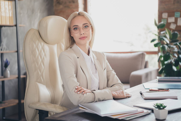 Portrait of attractive young business person sitting chair folded hands look camera office room inside. - Foto, immagini
