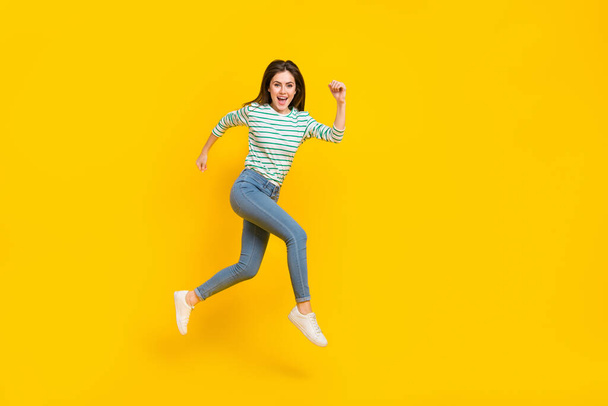 Full length profile side photo of cheerful energetic good mood female running traveling isolated on yellow color background. - Fotó, kép