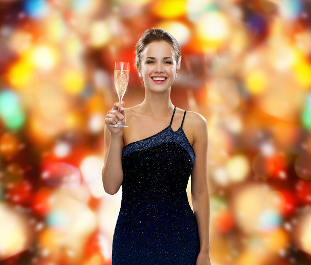 smiling woman holding glass of sparkling wine - Photo, image