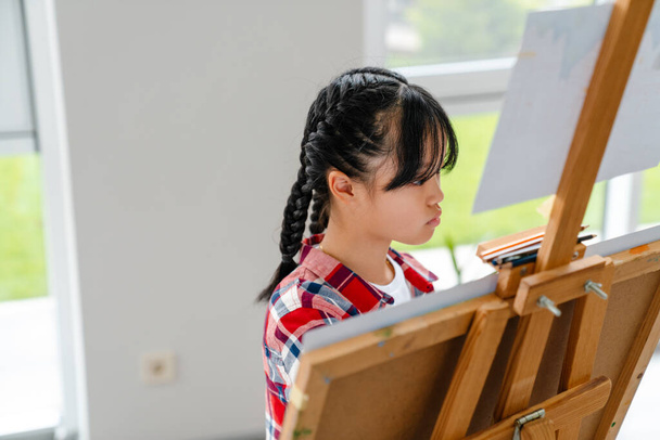 Asian girl drawing during class in art school indoors - 写真・画像