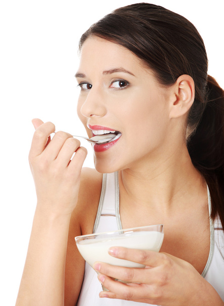 Young beautiful woman eating yogurt - Foto, Imagen