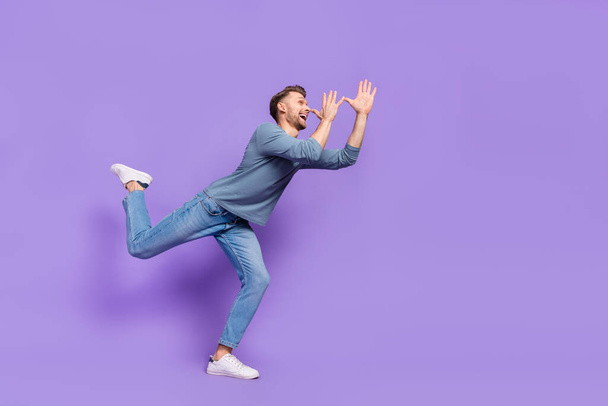 Photo of excited funky guy wear grey shirt having fun dancing hands arms nose isolated violet color background. - Foto, Bild
