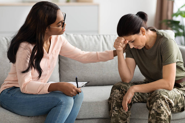 Чорний психолог леді втішає військову жінку під час сеансу терапії в офісі, жінка-солдат страждає після травматичного стресового розладу Отримання професійної допомоги від психотерапевта
 - Фото, зображення