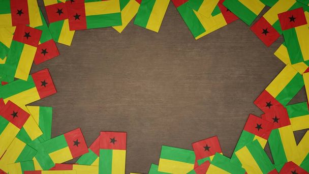 Frame made of paper flags of Guinea-Bissau arranged on wooden table. National celebration concept. 3D illustration - Photo, Image