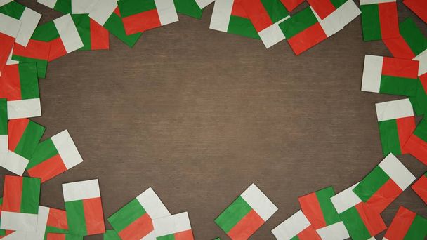 Telaio realizzato con bandiere di carta del Madagascar disposte su tavolo in legno. Concetto di celebrazione nazionale. Illustrazione 3D - Foto, immagini