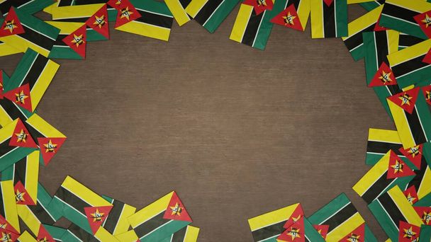 Telaio realizzato con bandiere di carta del Mozambico disposti su tavolo di legno. Concetto di celebrazione nazionale. Illustrazione 3D - Foto, immagini