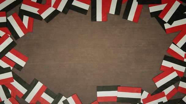 Rámeček z jemenských papírových vlajek rozložených na dřevěném stole. Národní koncepce oslav. 3D ilustrace - Fotografie, Obrázek