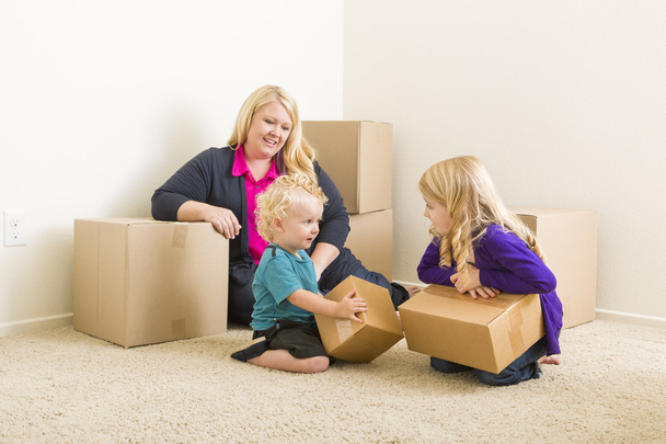 Jonge gezin In lege ruimte met Verhuisdozen - Foto, afbeelding