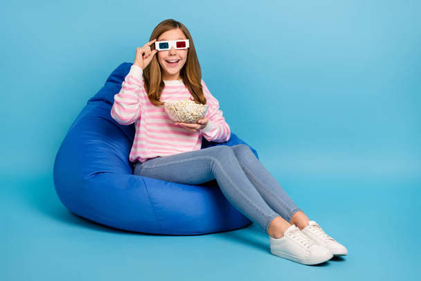 Full length portrait of positive excited girl touch 3d glasses hold pop corn bowl isolated on blue color background. - Valokuva, kuva