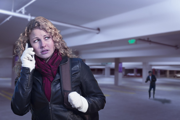 Φοβόμαστε νεαρή γυναίκα για κινητό τηλέφωνο σε δομή χώρων στάθμευσης - Φωτογραφία, εικόνα
