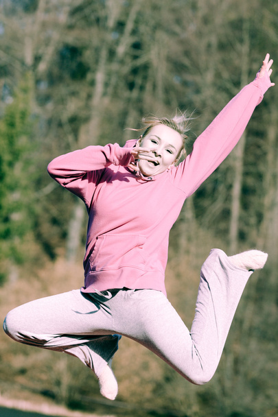 Teenage girl jumping outdoors - Photo, image