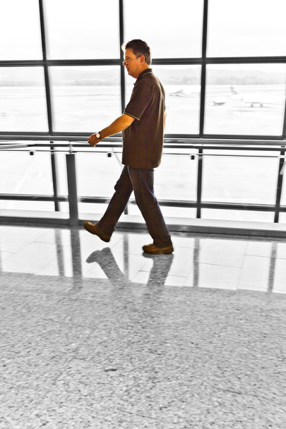 άνθρωπος περπατώντας στους αίθουσα αναχώρησης - Φωτογραφία, εικόνα