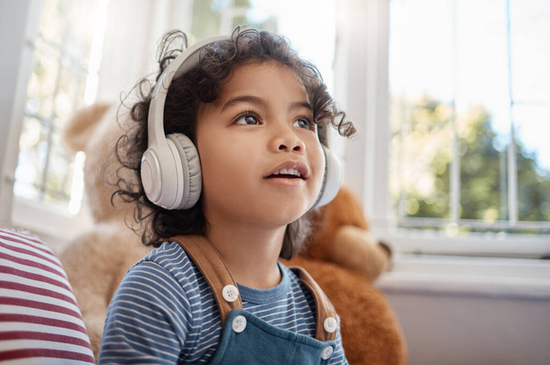 Shot of an adorable young boy using headphones in his bedroom at home. - Photo, Image