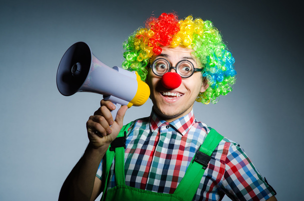 Clown met luidspreker tegen gordijn - Foto, afbeelding