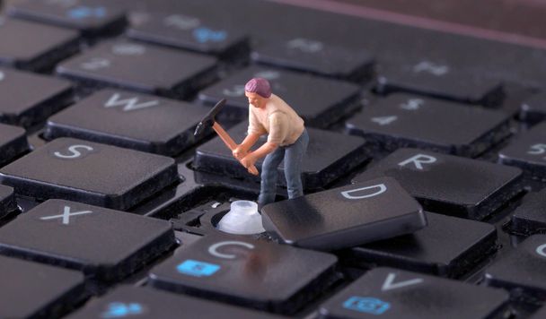 Miniaturarbeiter mit Spitzhacke an der Tastatur - Foto, Bild