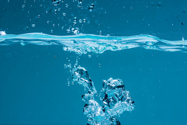 Superficie de agua azul sobre fondo blanco
 - Foto, Imagen