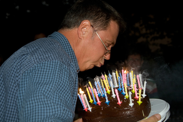 Man blows out his birthday candles - Photo, Image