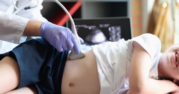 Esame medico della bambina con l'ausilio di ultrasuoni. Sonografo muove trasduttore su addome bambino e reni. Diagnostica clinica professionale e trattamento - Filmati, video