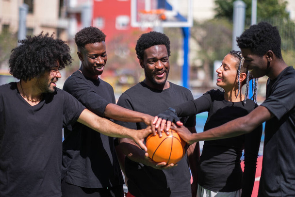 Groep vrienden verenigd om basketbal te spelen op gekleurde veld - Foto, afbeelding