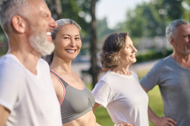 Togetherness. A group of mature people in sportswear feeling great together in the park - Foto, Bild