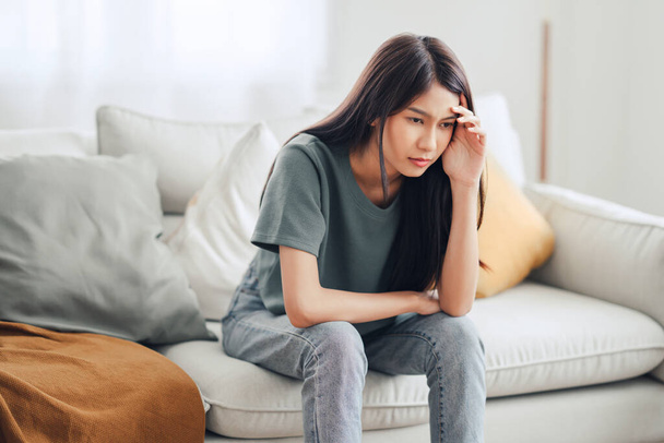 Sad tired young asian woman touching forehead having headache migraine or depression, upset frustrated girl troubled with problem feel stressed, Grief sorrow concept. - Photo, Image