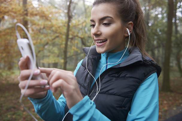 Nainen kuuntelee musiikkia juostessaan
 - Valokuva, kuva