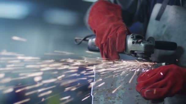 Dělník v továrně pomocí úhlové brusky - Záběry, video