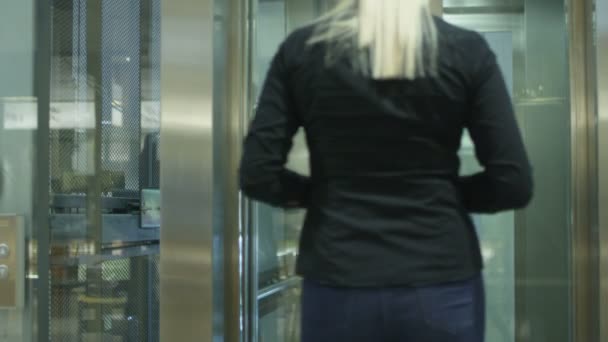 El hombre de negocios y la mujer están subiendo al ascensor
 - Metraje, vídeo
