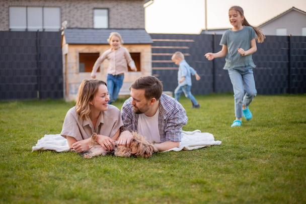 Családi portré. boldog család anya, apa, lánya, fia pihennek és szórakoznak a házuk hátsó udvarán. - Fotó, kép