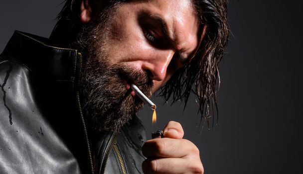 Uomo barbuto sensuale che fuma sigarette. Elegante hipster con accendino. Dipendenza da nicotina. Primo piano - Foto, immagini