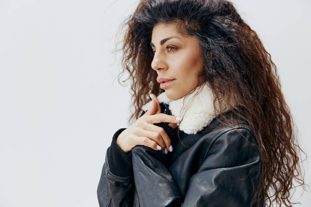 Beyaz Stüdyo arka planında izole edilmiş kürk yakalı, siyah ceketli şık kıvırcık, Latin bir bayan. Moda Satışı Yeni Koleksiyon Konsepti Profili - Fotoğraf, Görsel