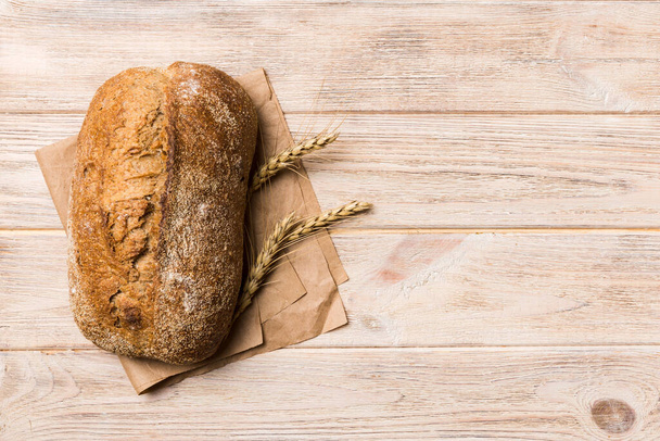 Свежий домашний хлеб из цельного пшеницы. хлеб на салфетке на деревенском фоне, свежий хлеб вид сверху. - Фото, изображение