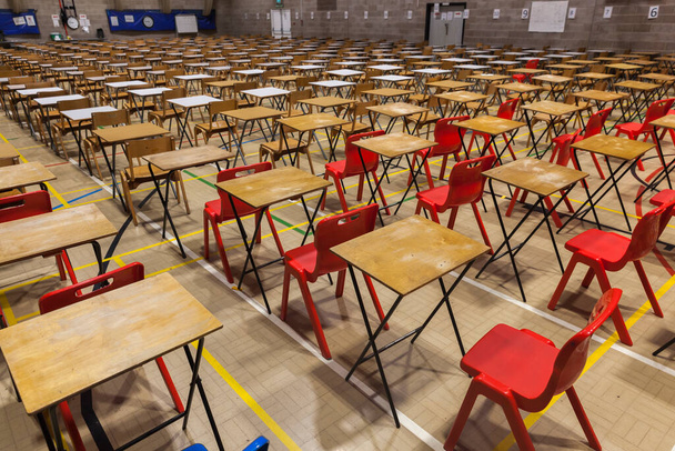 Экзаменационные столы и стулья, установленные в сетке во время экзамена в школе. - Фото, изображение