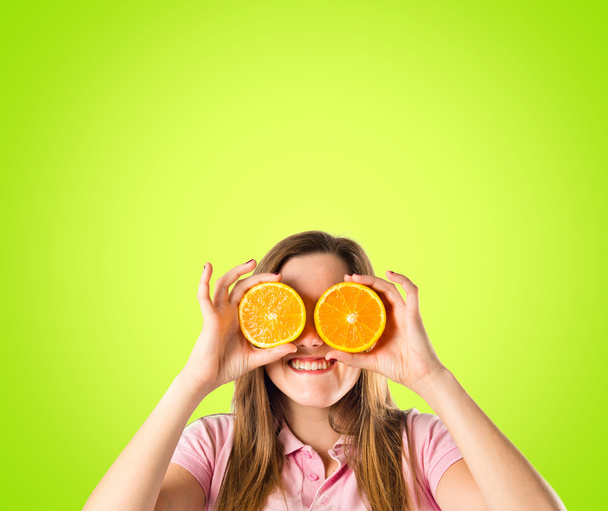 Девушка с апельсинами на зеленом фоне
 - Фото, изображение