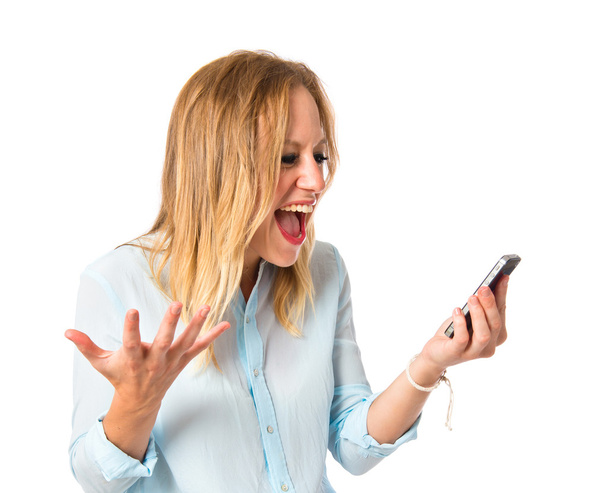 Frustrated girl talking to mobile over white background - Photo, Image