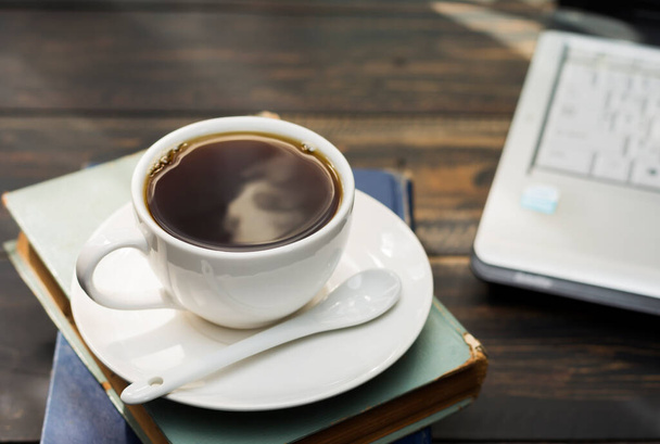 На столі покладена чашка білої кави. офіс або вдома з портативним комп'ютером клавіатури планшетного ПК
 - Фото, зображення