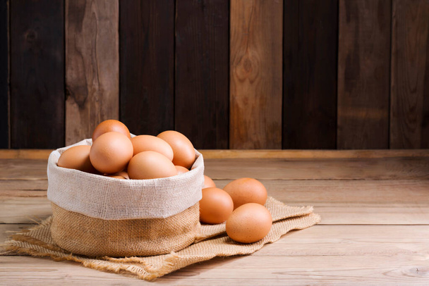 Świeże organiczne jaja kurze z farmy na wiejskim drewnianym stole. - Zdjęcie, obraz