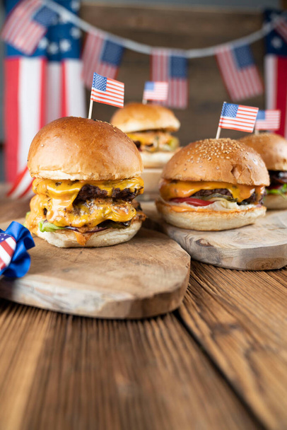 Fourth of July celebration. American flag and decorations. Burgers on rustic wooden table. - Φωτογραφία, εικόνα