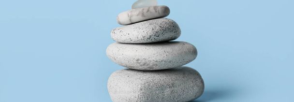 Stack of spa stones on light blue background. Zen concept - Zdjęcie, obraz