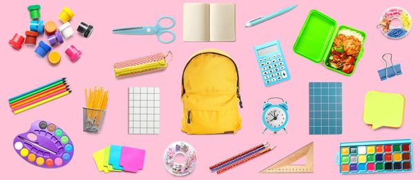 Рюкзак з набором шкільних приладдя на рожевому фоні
 - Фото, зображення
