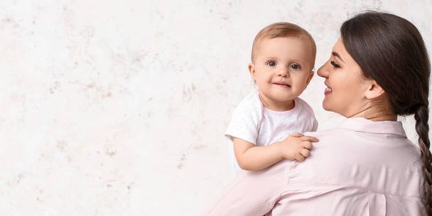 Happy mother and cute little baby on light background with space for text - Valokuva, kuva