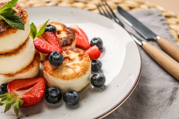Plate with delicious cottage cheese pancakes, berries and mint leaves, closeup - Фото, изображение