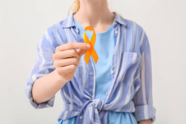 Женщина с оранжевой лентой на белом фоне. Концепция рака почек - Фото, изображение