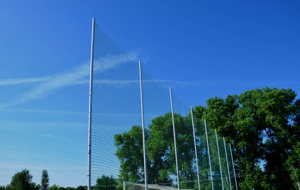 korkeat turvaverkot valmistettu metalli pylväät ja verkot rugby kenttä, jalkapallo urheilullinen stadion. katsojat istuvat lähellä ja ne on suojattu pallot ja lentävät esineet - Valokuva, kuva