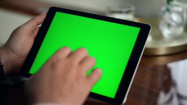 Felnőtt kéz lopás zöld tabletta képernyő közelkép. Férfi kezében krómkulcs számítógép böngészés internet. Felismerhetetlen üzleti menedzser mockup pad használatával. Gazdag üzletember ellenőrzi a vállalati statisztikák adatait - Felvétel, videó