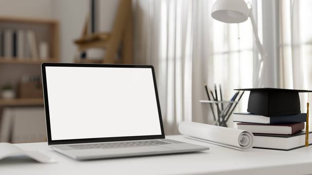 Modern diákasztal munkaterület hordozható laptop számítógép fehér képernyő mockup, könyv, írószer, asztali lámpa és akadémiai sapka az asztalon. 3d renderelés, 3d illusztráció - Fotó, kép