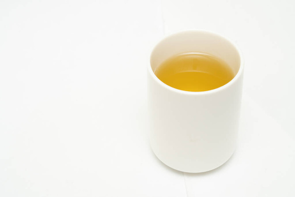 Groene thee op een witte achtergrond. Afbeelding van Japanse groene thee. Kopje thee geïsoleerd op witte achtergrond - Foto, afbeelding