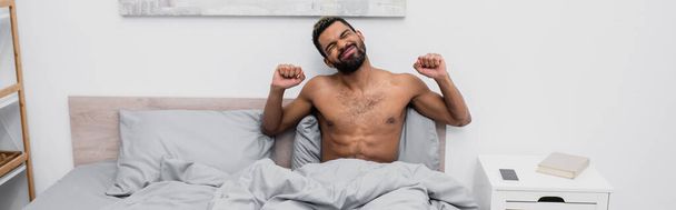 homme afro-américain torse nu avec les cheveux teints étirant dans le lit, bannière - Photo, image