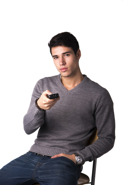 Handsome young man holding remote control, isolated - 写真・画像