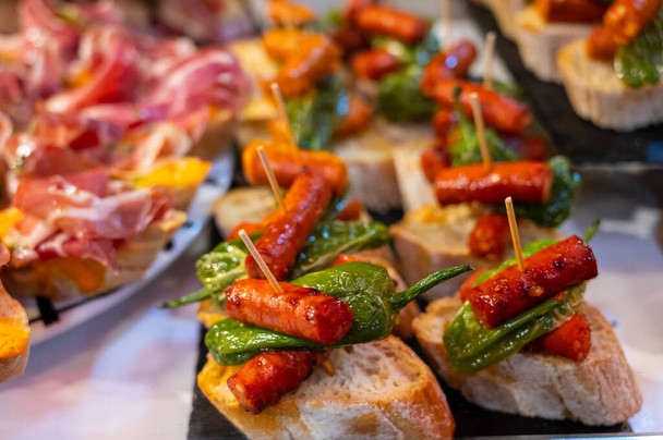 Typická svačinka Baskicka a Navarry, pinchos nebo pinxtos, malý kousek chleba s různými polevy, podávané v baru, Bilbao, Španělsko, zblízka - Fotografie, Obrázek